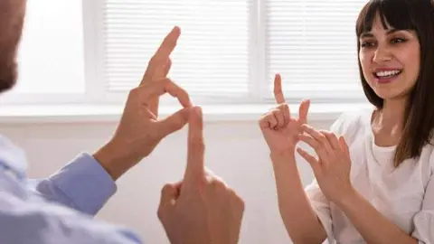 Un hombre y una mujer se comunican en lengua de signos | Foto de Servimedia