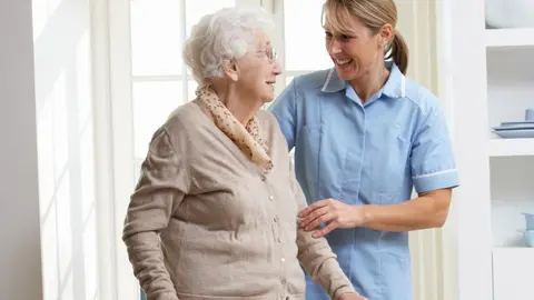 anciana de pie con enfermera