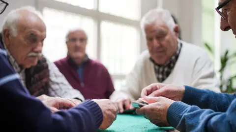 Personas mayores jugando a las cartas