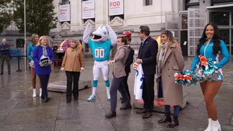 El alcalde, José Luis Martínez-Almeida, hace un lanzamiento con un balón de fútbol americano hacia el público allí presente