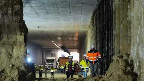 Operarios y maquinaria en la conexi&oacute;n de dos galer&iacute;as excavadas en las obras de soterramiento de la A5