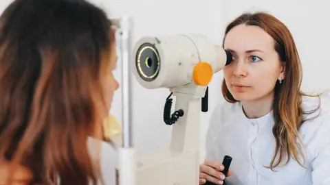 Una oftalm&oacute;loga revisa la visi&oacute;n de una paciente joven | Foto de 123RF/kall1st0