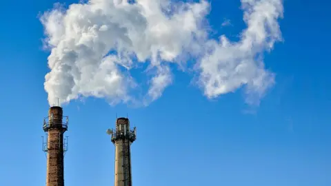 Emisiones nocivas a la atm&oacute;sfera procedentes de la industria. Gases de efecto invernadero y calentamiento global - Foto de Alexandrum79 de Getty Images (Canva)