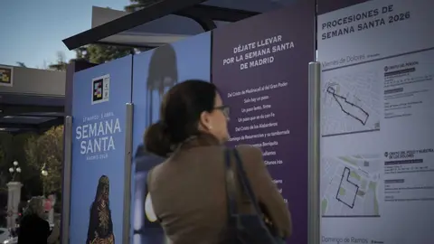 Ciudadana leyendo informaci&oacute;n sobre Semana Santa en marquesina EMT Madrid