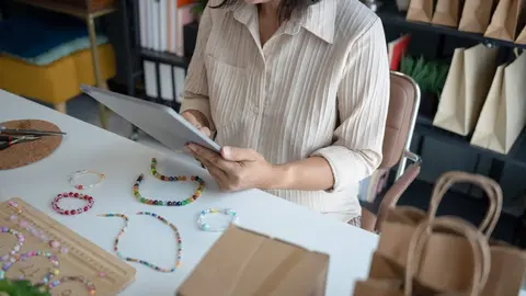 Mujer, due&ntilde;a de negocio, gestiona pedidos de comercio electr&oacute;nico en l&iacute;nea - Foto de  charliepix