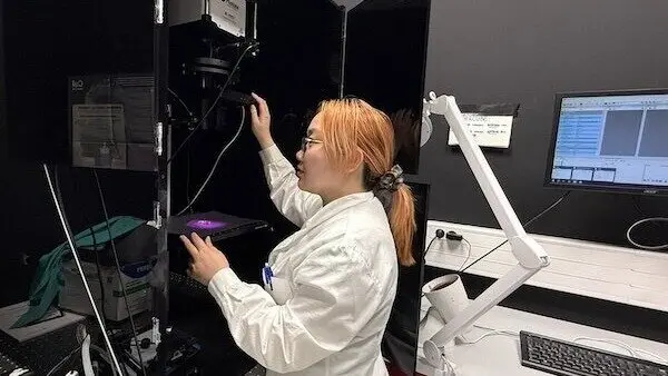 La estudiante Liyan Ming, primera autora del estudio, prepara una medición de fluorescencia - UAM