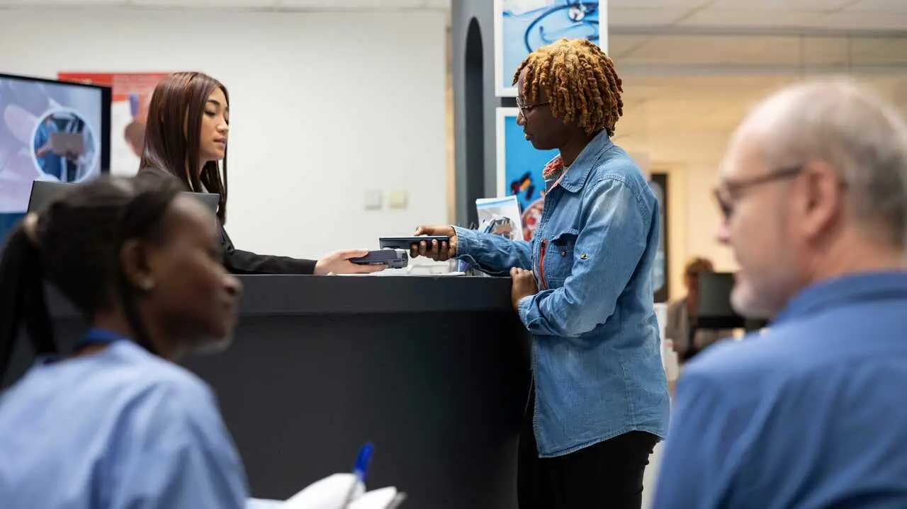 Personas migrantes hacen tramites en una oficina | Foto de 123RF/dragoscondrea