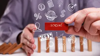 Una persona ordena fichas que representan la econom&iacute;a social - Foto de 123RF/Photonphoto