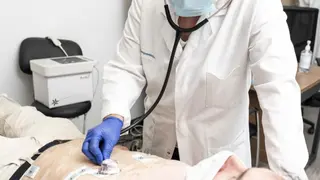 Un m&eacute;dico explorando a un paciente, ambos con mascarilla - Foto de Jorge Villa Bola&ntilde;os/Servimedia