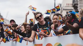 Varias personas con banderas Lgtbi+ manifest&aacute;ndose | Foto de 123RF/smutkoalex