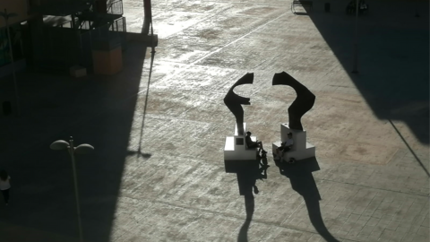 La sombra espesa de la tarde en un pueblo del Levante español, con plaza enlosetada.