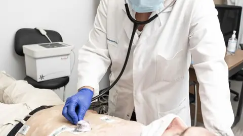 Un m&eacute;dico explorando a un paciente, ambos con mascarilla - Foto de Jorge Villa Bola&ntilde;os/Servimedia
