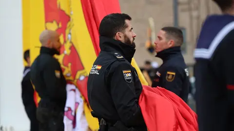 Imagen de un policía cogiendo la bandera de España durante el acto de conmemoración - Foto de la Policía Nacional