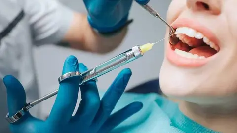 Dentista pinchando anestesia a un paciente - Getty Images