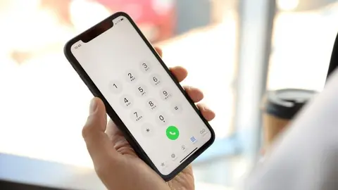 Man holding  Smartphone  with keypad on screen indoors, closeup