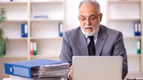 Un trabajador veterano en su escritorio | Foto de 123RF/Elnur