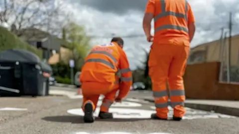 Dos operarios señalizan en una calle el camino seguro | Foto del Ayuntamiento de Majadahonda