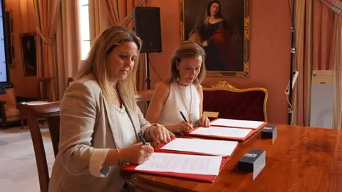 La concejala delegada de Turismo, Almudena Maíllo, y la delegada de Turismo de Sevilla, Angie Moreno, durante la firma del convenio de colaboración turística