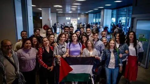 Mónica García junto a los miembros de la flotilla y personas que los han recibido en el aeropuerto | Foto de las redes sociales de Mónica García