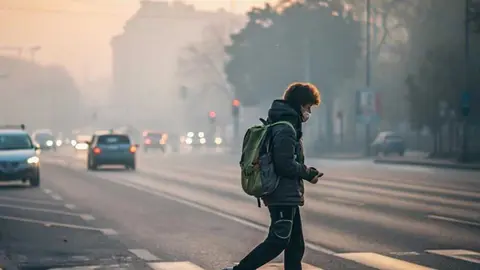 Peat&oacute;n cruzando paso de cebra mirando el m&oacute;vil