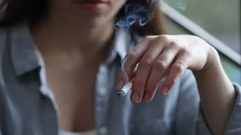 Mujer con un cigarrrillo en la mano | Foto de 123RF/ liudmilachernetska