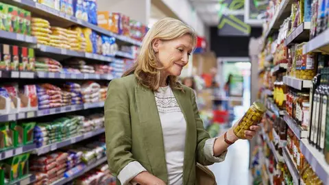Mujer comprando en el supermercado, revisando la etiqueta - Foto de francescoridolfi.com de Rido (Canva)