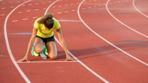 Mujer atleta preparada para hacer un sprint - Imagen de Dapa Images