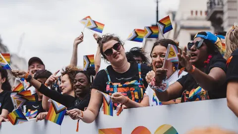 Varias personas con banderas Lgtbi+ manifest&aacute;ndose | Foto de 123RF/smutkoalex