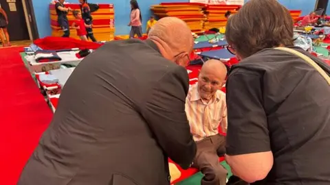 El obispo auxiliar de la Di&oacute;cesis de Getafe, Jos&eacute; Mar&iacute;a Avenda&ntilde;o, visita a personas que estaban evacuadas en polideportivos por los incendios forestales - Foto de la Di&oacute;cesis de Getafe