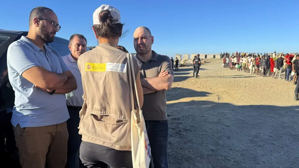 El delegado del Gobierno en Ceuta, junto a una fila de inmigrantes en la playa | Foto de la Delegaci&oacute;n del Gobierno en Ceuta